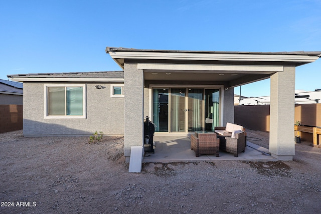 rear view of property with an outdoor living space and a patio