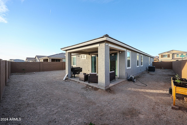 rear view of house with central air condition unit and a patio area