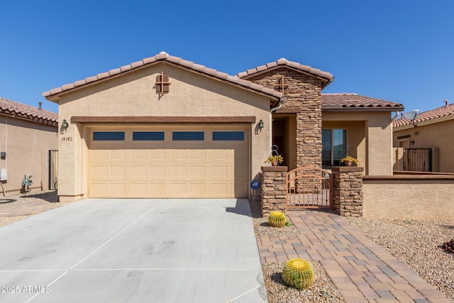 view of front facade with stucco siding, driveway, a tile roof, and a garage