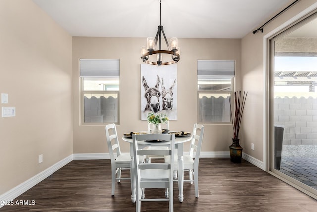 dining space featuring baseboards, dark wood-type flooring, and a chandelier