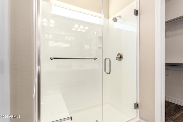 full bath with a spacious closet and a shower stall