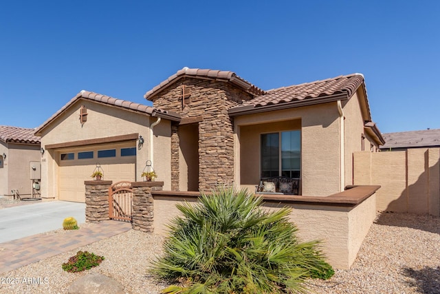 mediterranean / spanish-style house with stucco siding, driveway, stone siding, fence, and an attached garage