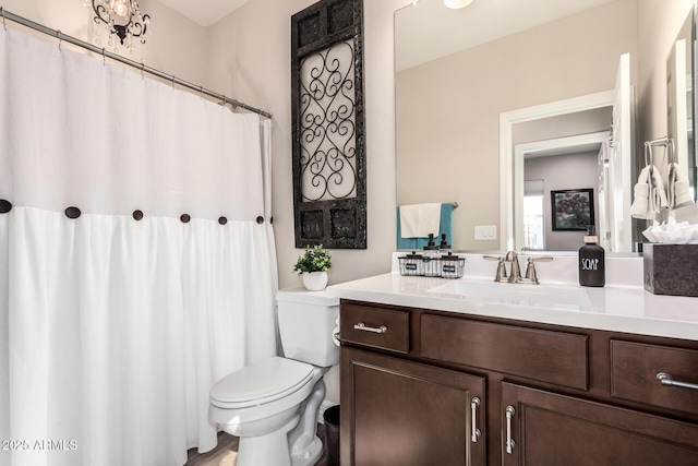 bathroom featuring curtained shower, toilet, and vanity