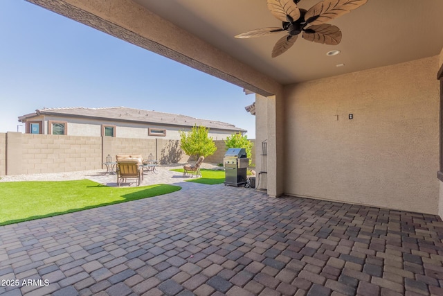 view of patio featuring a grill, ceiling fan, and fence