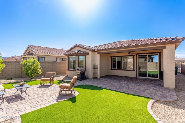 back of house with a patio area, a tiled roof, a fenced backyard, and stucco siding