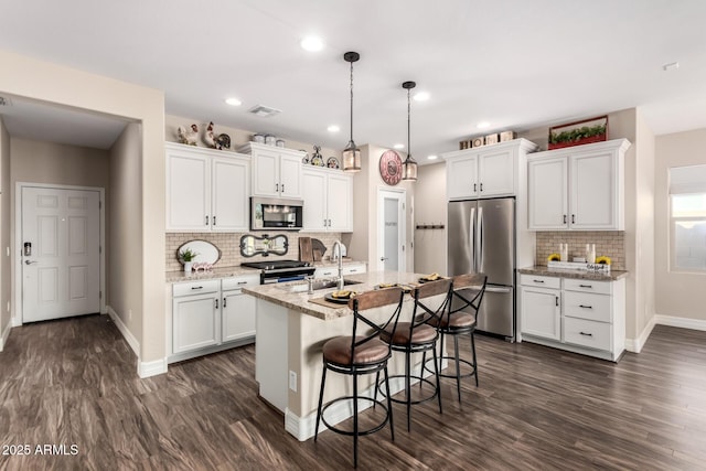 kitchen with a sink, white cabinets, dark wood finished floors, and stainless steel appliances