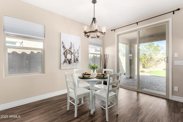 dining area featuring baseboards, dark wood-style flooring, and a chandelier