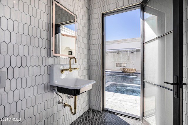 bathroom featuring sink and tile walls