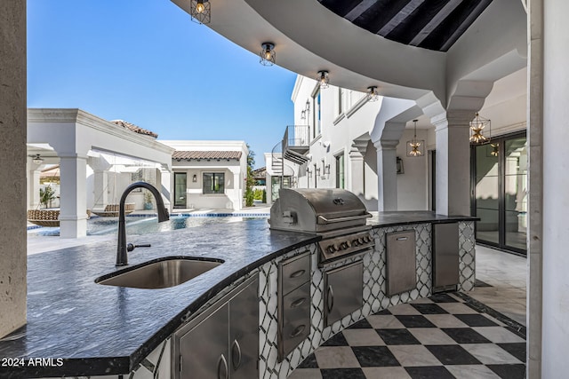 view of patio with pool water feature, area for grilling, sink, and an outdoor kitchen