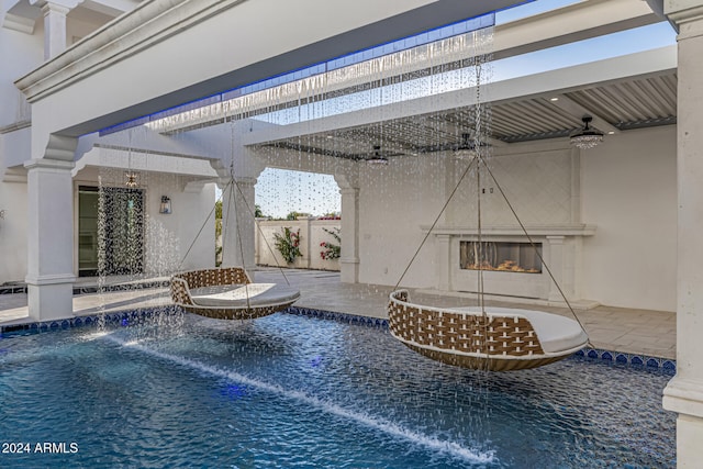 view of swimming pool with pool water feature and ceiling fan