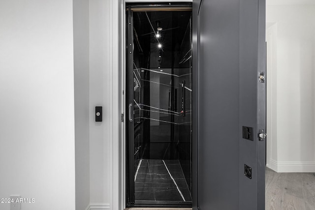 details featuring wood-type flooring and elevator