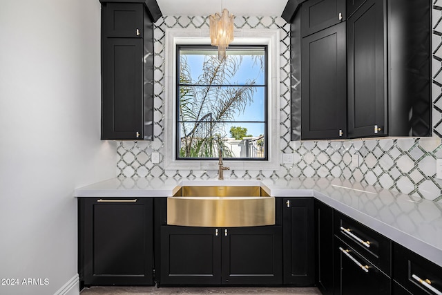 kitchen featuring backsplash, light stone counters, and sink