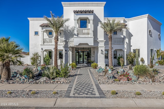 mediterranean / spanish home featuring a balcony and french doors