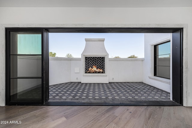 interior space with wood-type flooring and an outdoor fireplace