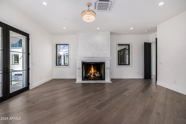 unfurnished living room featuring dark hardwood / wood-style flooring and a large fireplace