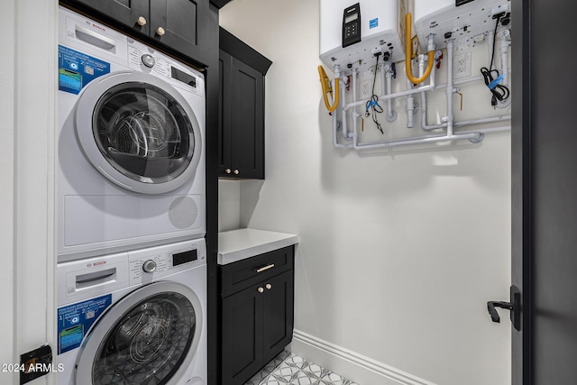 laundry room featuring cabinets, stacked washing maching and dryer, and light tile patterned flooring