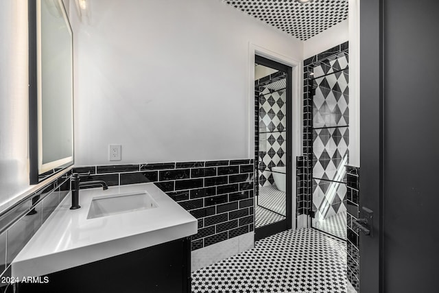 bathroom with vanity and tile walls