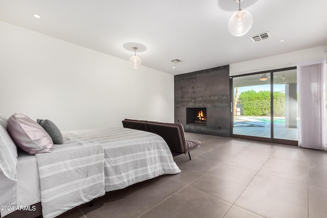 bedroom with access to outside and a fireplace