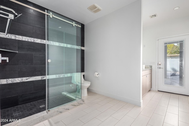 bathroom with tile patterned flooring, vanity, a shower with door, and toilet