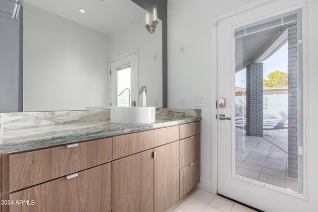 bathroom with tile patterned flooring, vanity, and a wealth of natural light