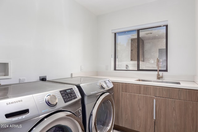 laundry room featuring cabinets, sink, and washer and clothes dryer