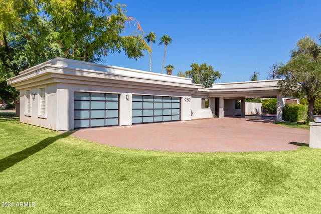 garage with a carport and a lawn