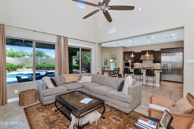 tiled living room with a towering ceiling and ceiling fan