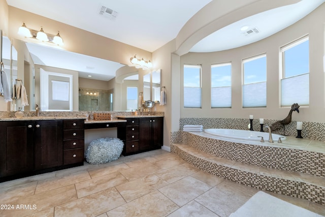 bathroom featuring vanity and independent shower and bath