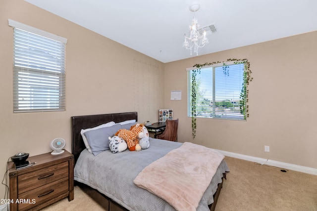 carpeted bedroom featuring an inviting chandelier