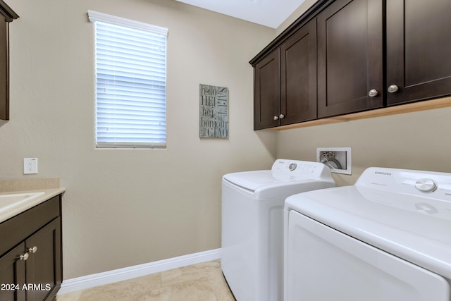 laundry area with light tile patterned floors, washing machine and dryer, and cabinets