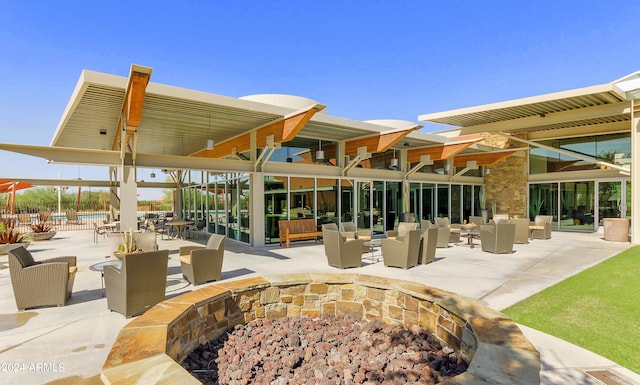 view of community featuring a fire pit and a patio area