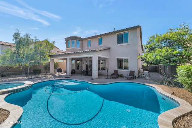 exterior space featuring a swimming pool with hot tub and a patio