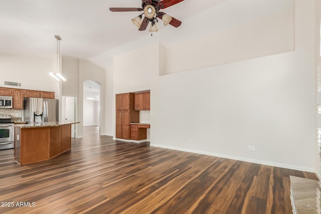 869 W Emerald Island Dr, Gilbert, AZ 85233 - unfurnished living room featuring ceiling fan, arched walkways, dark wood finished floors, high vaulted ceiling, and baseboards