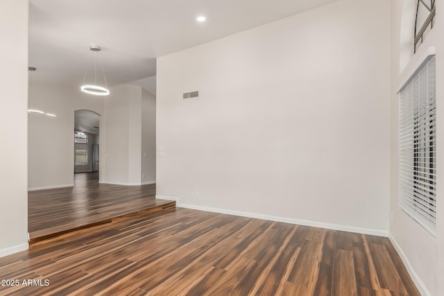 869 W Emerald Island Dr, Gilbert, AZ 85233 - spare room with arched walkways, dark wood-style flooring, baseboards, and recessed lighting