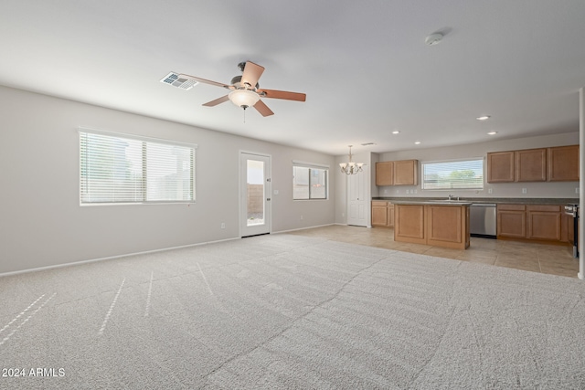 unfurnished living room featuring light carpet, sink, and ceiling fan with notable chandelier