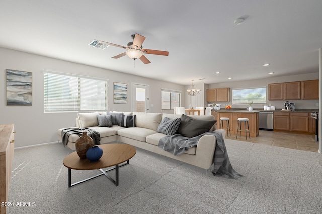 living room featuring light carpet and ceiling fan with notable chandelier