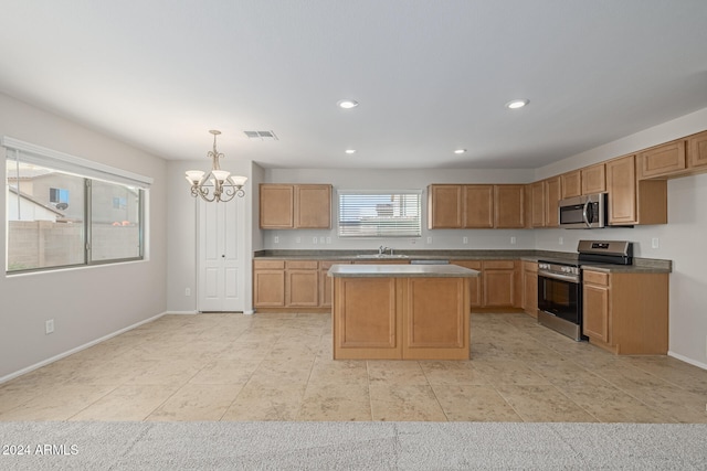 kitchen featuring sink, stainless steel appliances, an inviting chandelier, pendant lighting, and a kitchen island