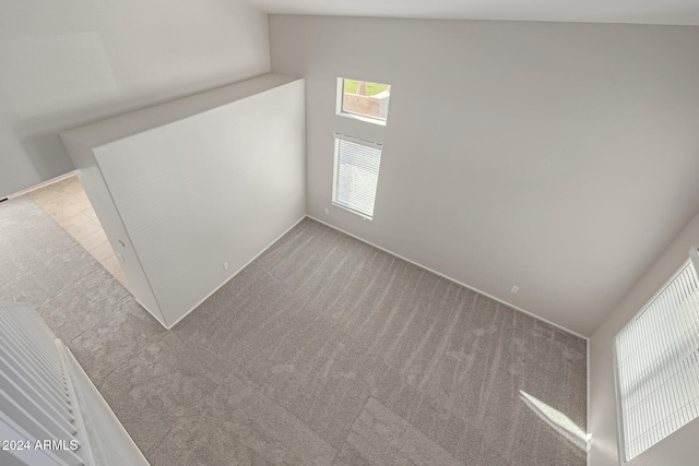 interior space featuring carpet floors and vaulted ceiling
