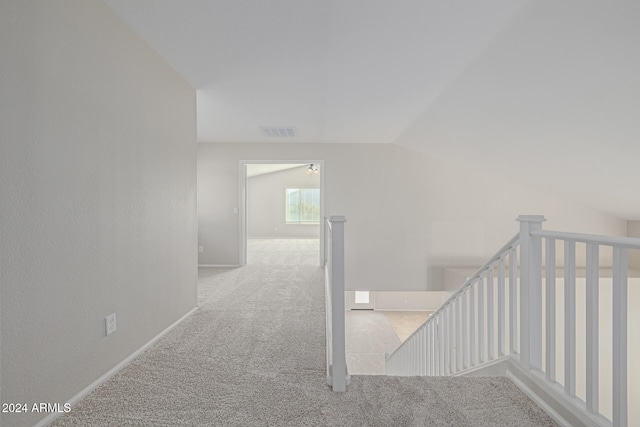staircase with carpet floors and vaulted ceiling