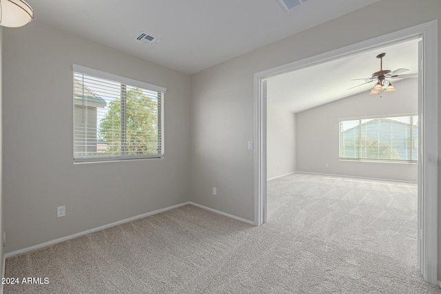 unfurnished room featuring light carpet, vaulted ceiling, and ceiling fan