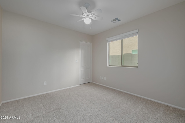 spare room with ceiling fan and light colored carpet
