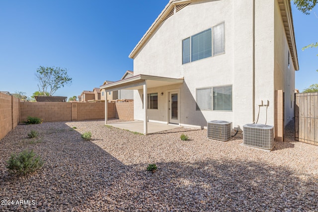 back of property with central AC unit and a patio area