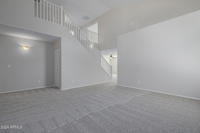 unfurnished living room featuring carpet, ceiling fan, and high vaulted ceiling