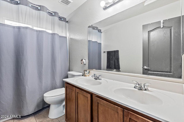 bathroom featuring vanity, toilet, and tile patterned flooring