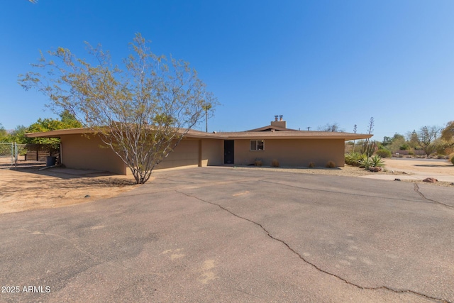 ranch-style home featuring a garage, driveway, and stucco siding