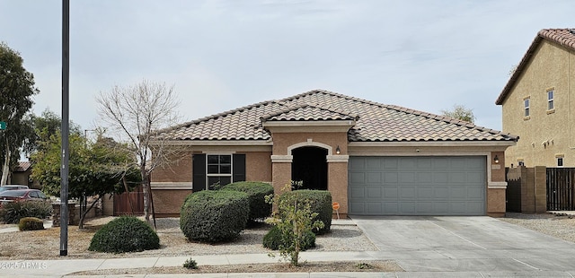 view of front of property with a garage, fence, concrete driveway, and a tiled roof