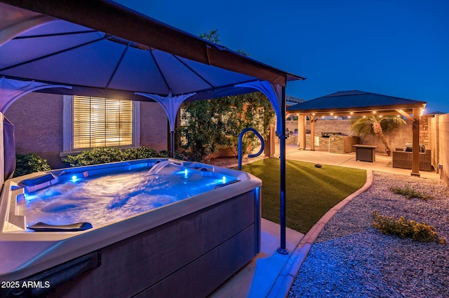 2678 S 172nd Dr, Goodyear, AZ 85338 - patio at night with a gazebo, a hot tub, and a fenced backyard