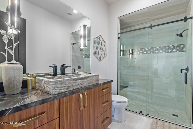 bathroom featuring visible vents, a shower stall, and vanity