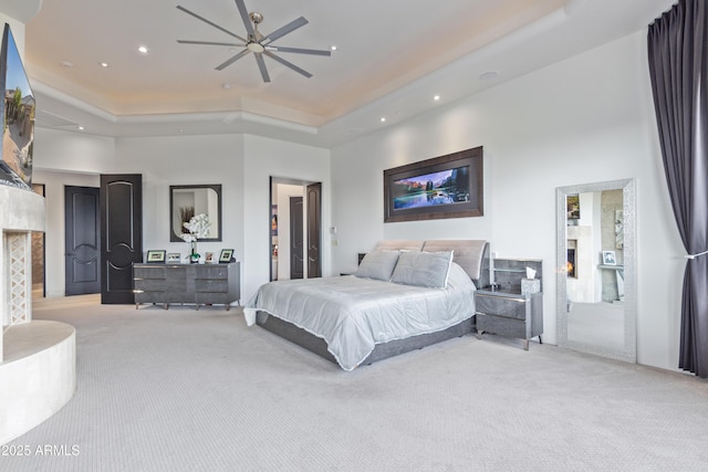 bedroom featuring carpet flooring, a lit fireplace, and a high ceiling