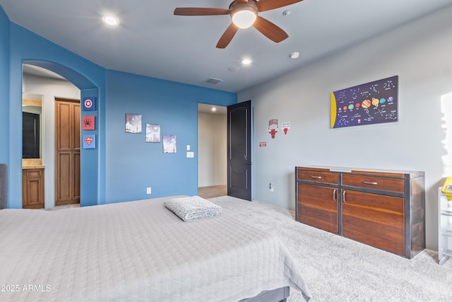 carpeted bedroom featuring a ceiling fan, arched walkways, visible vents, and recessed lighting